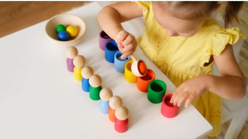 little girl, colorful wooden pegs