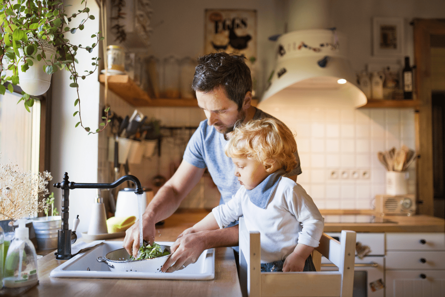 A man and a child cooking in a kitchen.